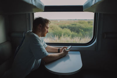 Side view of man sitting in car