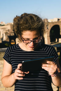 Young woman smiling while using digital tablet