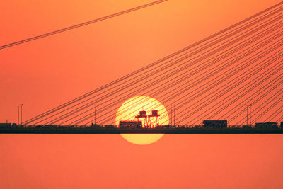 Vehicles on bridge during sunset