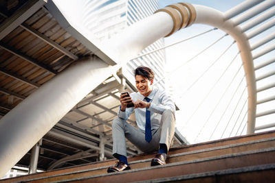 Full length portrait of man using mobile phone