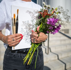 Midsection of woman holding bouquet