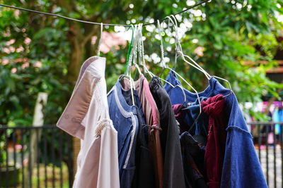 Dry clothes are hung on a rop in the yard of the house