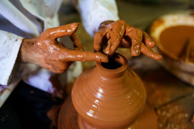 Cropped hand of person making pot