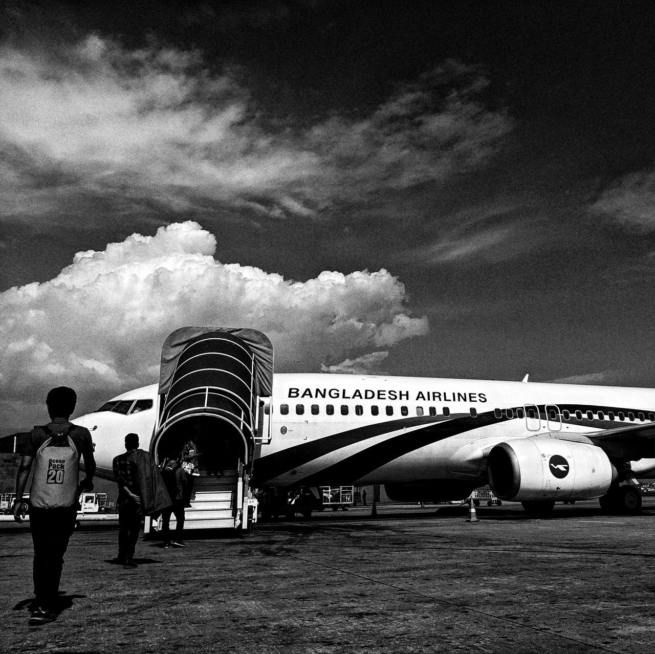 airliner, airplane, narrow-body aircraft, sky, cloud, transportation, aircraft, aviation, mode of transportation, air vehicle, vehicle, black and white, travel, monochrome, nature, airport, monochrome photography, men, jet aircraft, architecture, outdoors, day, adult