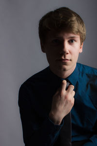 Portrait of young man wearing shirt against gray background