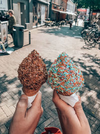 Midsection of person holding ice cream in city