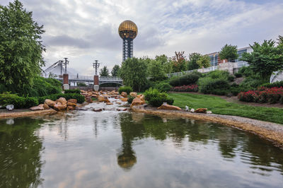 Scenic view of park in city against sky