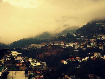 Residential town against foggy weather in sky at solan