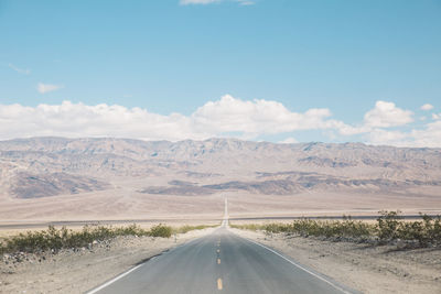Road by landscape against sky