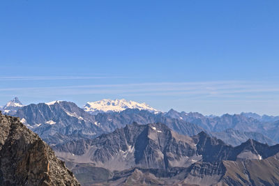 Scenic view of snowcapped mountains against blue sky