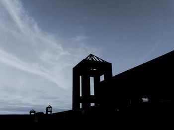 Low angle view of silhouette built structure against sky
