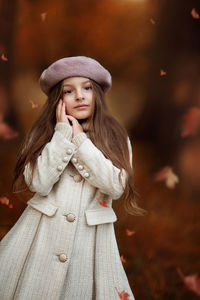 Portrait of young woman looking away while standing during autumn