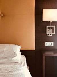 Electric lamp on bed against wall at home