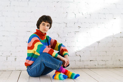 Portrait of boy sitting against wall