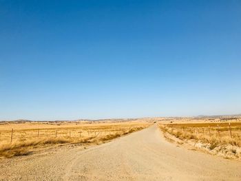 Scenic view of desert against clear blue sky