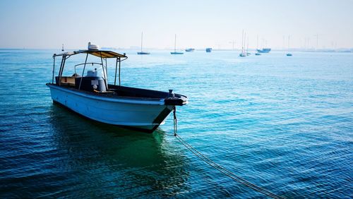 Sailboat moored on sea against clear sky