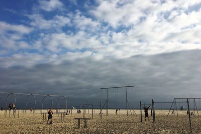 People playing on field against sky