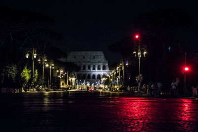 Illuminated buildings by street at night