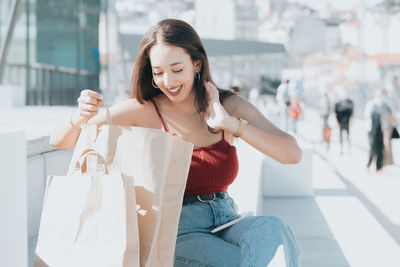 Smiling woman looking in shopping bag