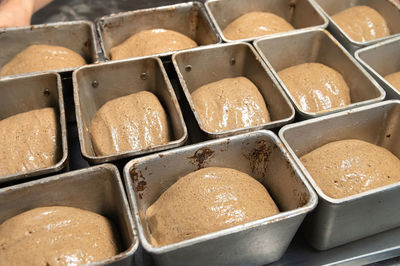 Bread dough in a black metal baking dish on a kitchen countertop. rye-free rye bread