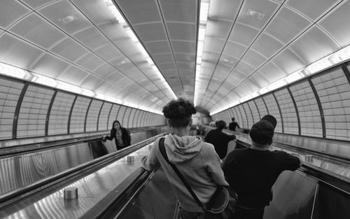 Rear view of people on escalator at subway station