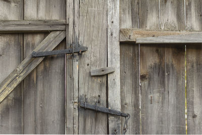 The old village gate.a fragment of an old wooden gate closed with an ancient bolt.