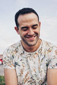 Portrait of smiling young man against sky