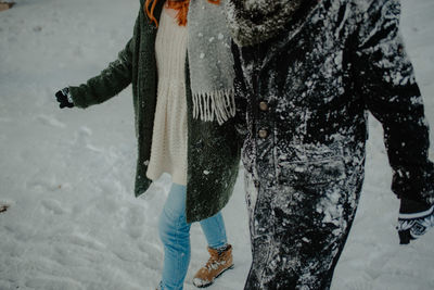 Low section of woman standing on snow covered land