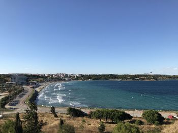 Scenic view of beach against clear blue sky