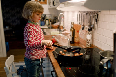 Side view of cooking food in kitchen at home