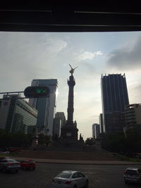 Statue of city buildings against cloudy sky