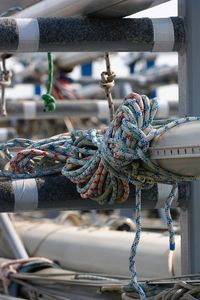 Close-up of ropes tied to railing at harbor