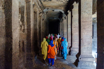 Rear view of people standing against wall