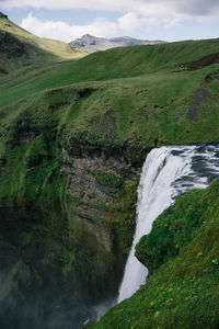 Scenic view of waterfall in green mountains 