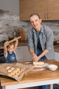 Father and child cooking on the kitchen with fun. family baking cinnabons