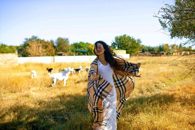 Portrait of young woman standing on field