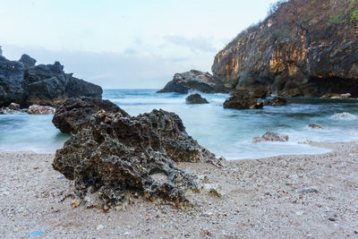 Coral rocks on the edge of the coastal beach hit by sea waves. coral beach with cliff shoreline.