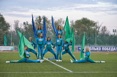 Group of people on grassland against the sky