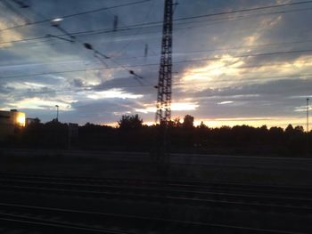 Electricity pylon against cloudy sky