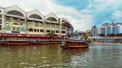 Boats in river with buildings in background