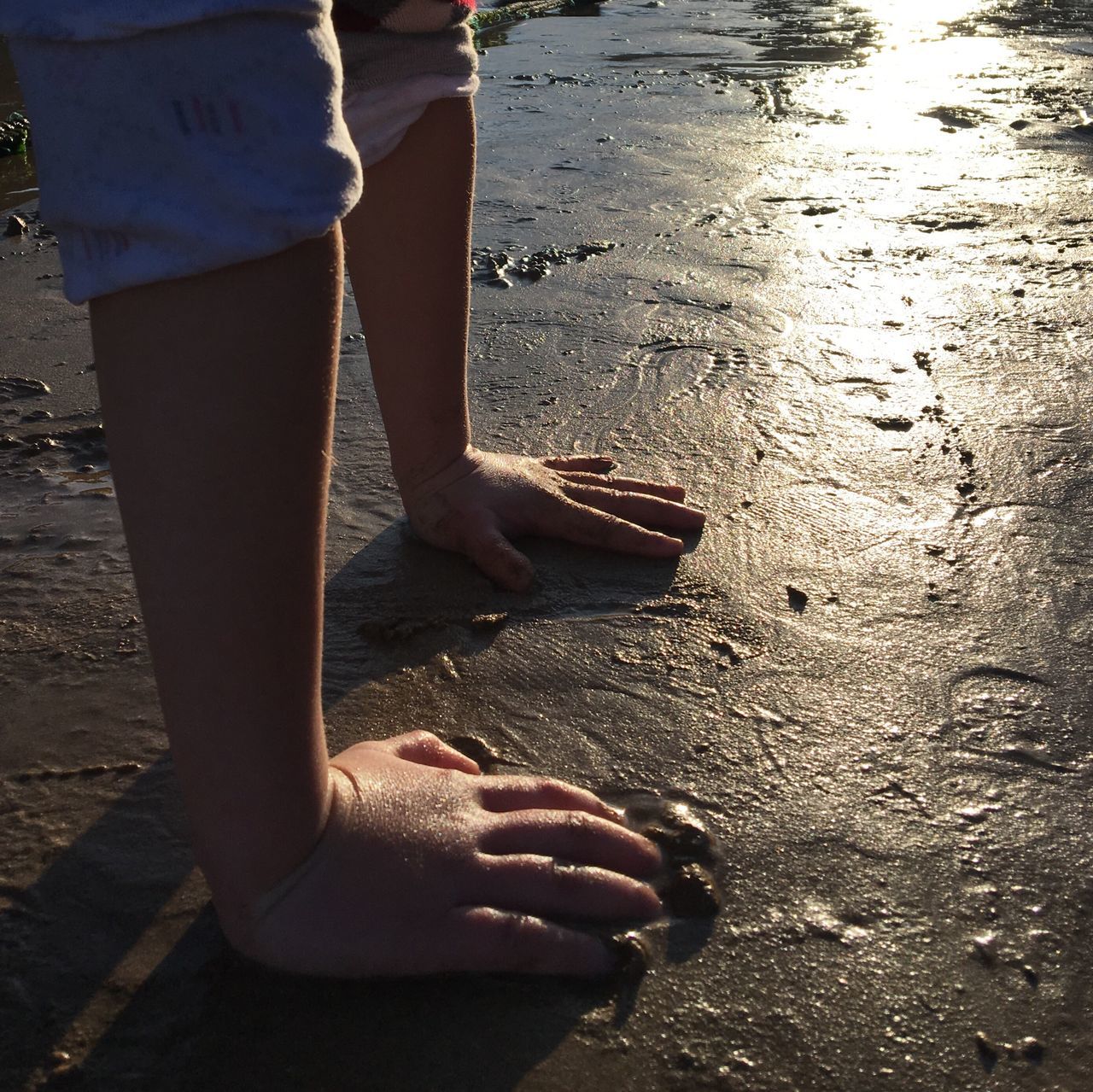 low section, human leg, barefoot, beach, sunlight, human body part, sand, outdoors, water, real people, sea, shadow, lifestyles, leisure activity, day, nature, one person, women, close-up, feet, people