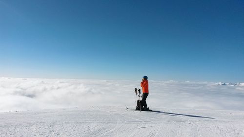 Full length of woman standing on snow field against sky