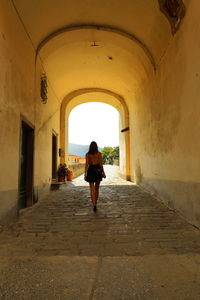Full length rear view of woman walking in building
