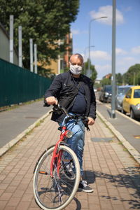 Rear view of man riding bicycle on street