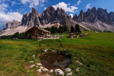 Built structure on field by mountains against sky