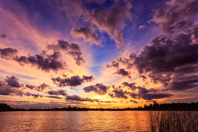 Scenic view of sea against dramatic sky during sunset