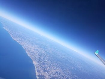 Aerial view of sea against clear blue sky