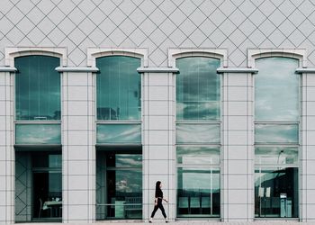 People standing by railing against wall