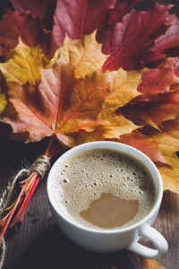 High angle view of coffee and autumn leaves on table
