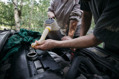 People pouring oil into engine